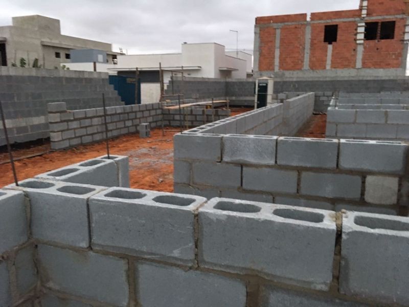 Construction site with unfinished cement block walls and visible rebar.