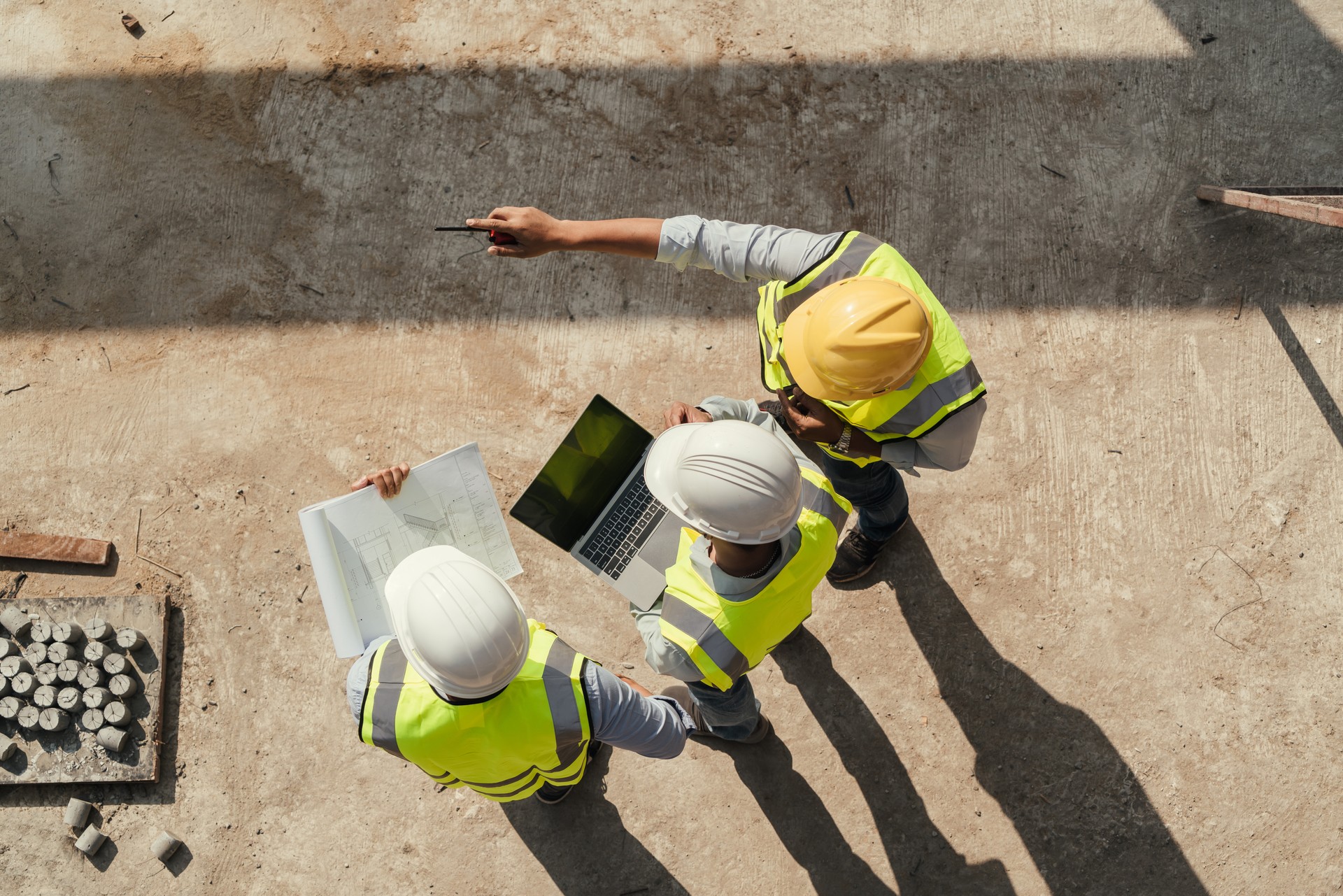 Vista superior, Equipe de engenharia de inspeção de construção usar computador tablet e blueprint trabalhando no canteiro de obras.